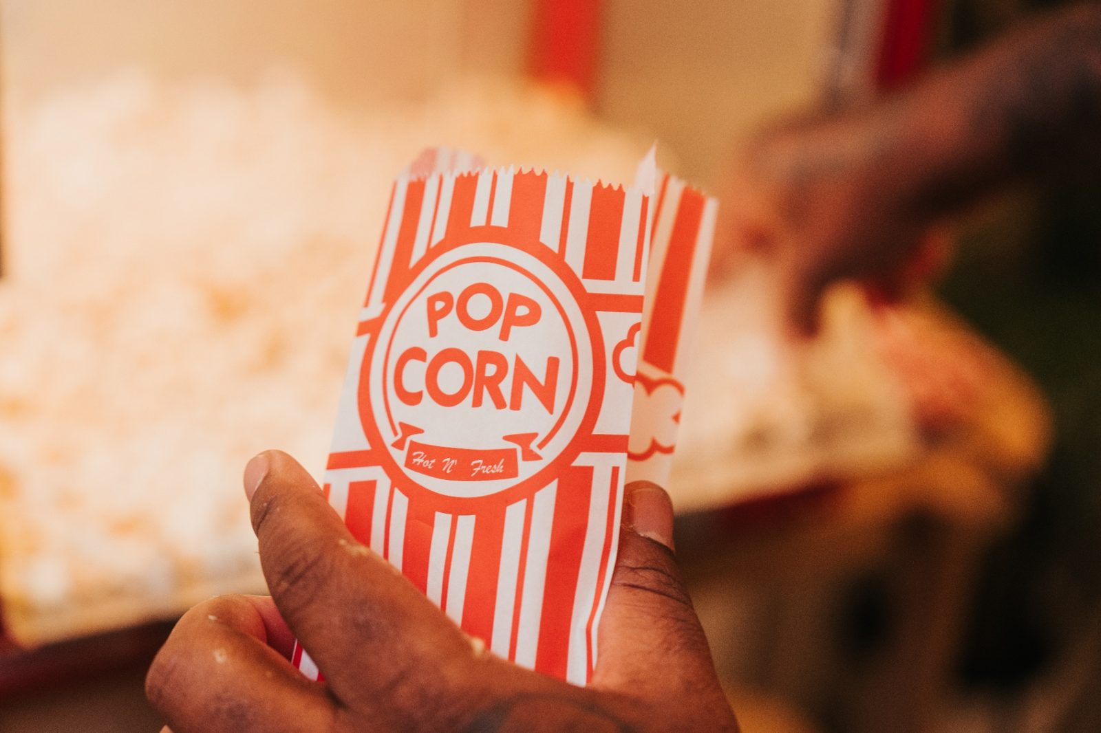 Atelier slime à Mons — sachet Pop Corn tenu par un participant à côté de la machine à pop-corn
